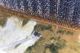 Cooling tower basin showing debris accumulation in Oklahoma summer