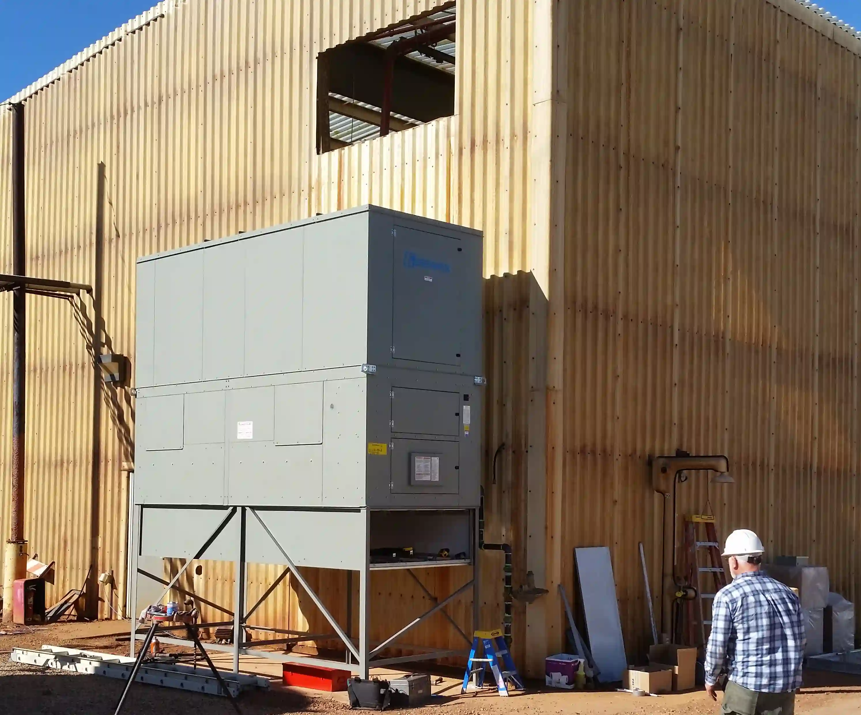 The new unit staged on its stand directly below the building's intake penetration