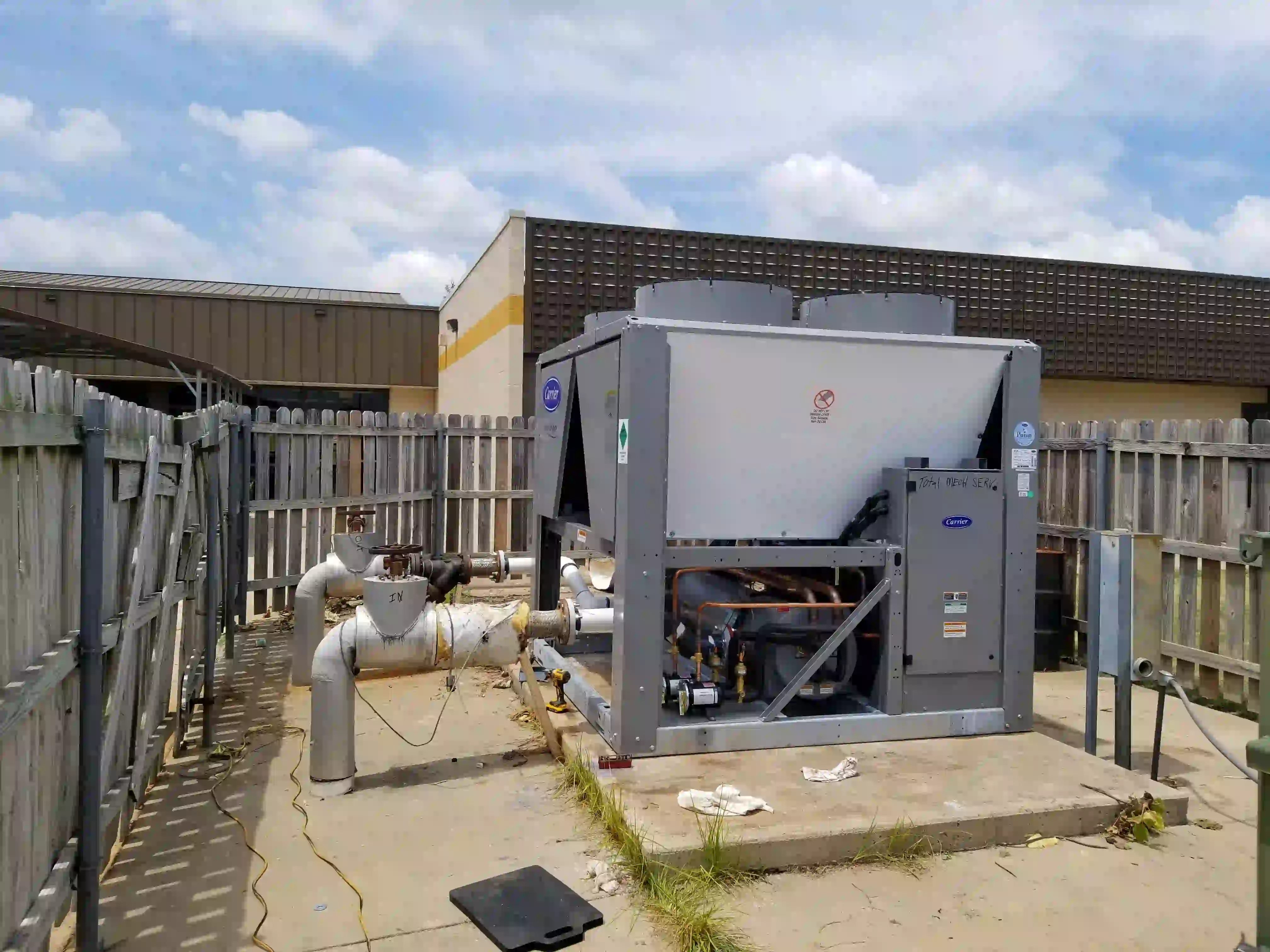Carrier chiller installation in progress: matching up piping and setting the unit