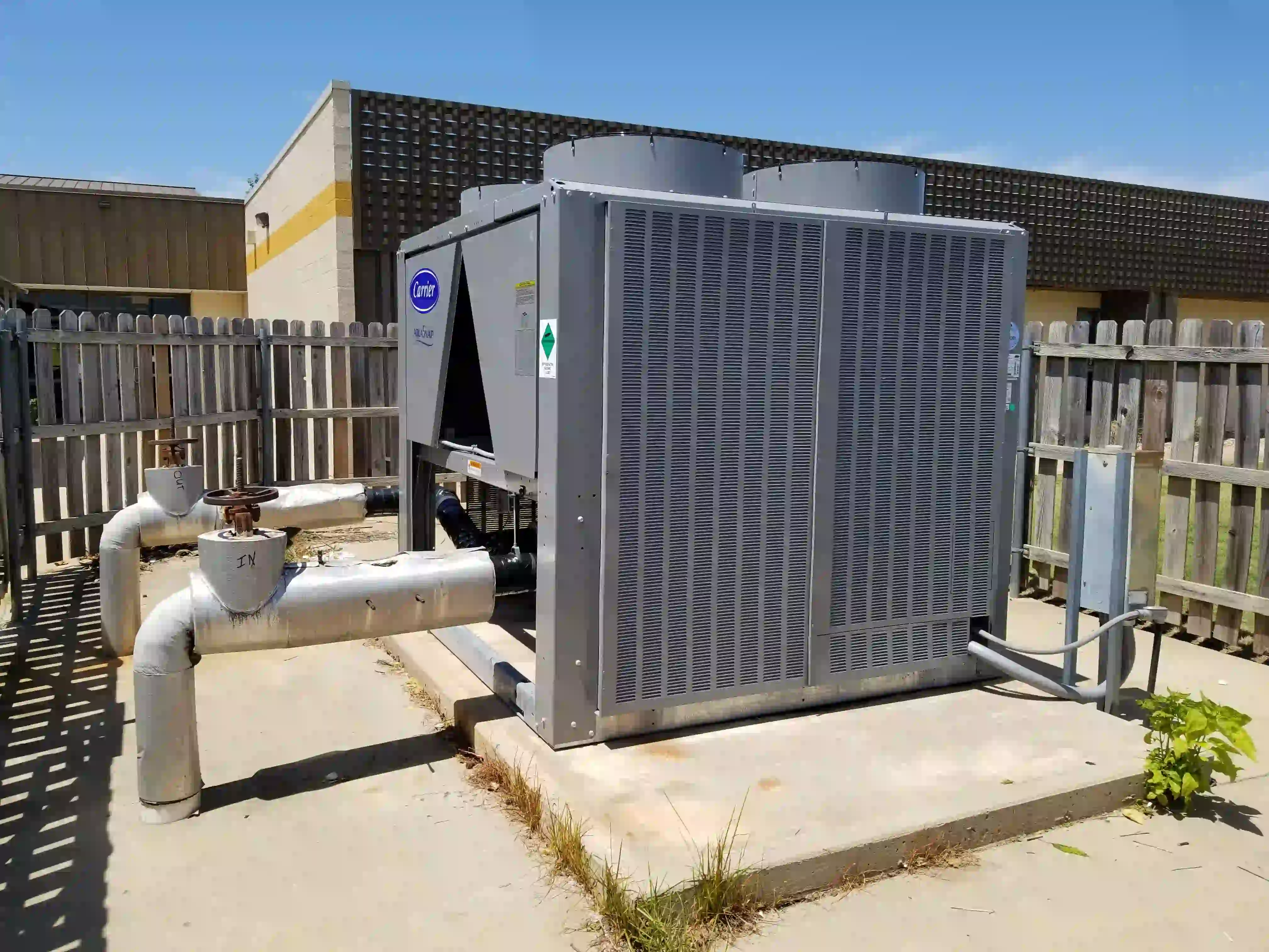 Finished Carrier chiller installation: clean, secure, and ready for hot season with hail guards installed